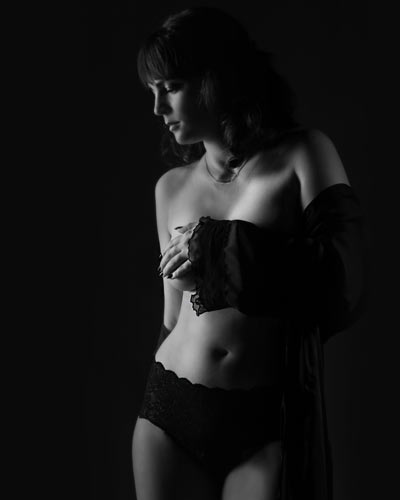 Zelfverzekerde schoonheid gevangen in contrast – een artistieke viering van tijdloze boudoirfotografie